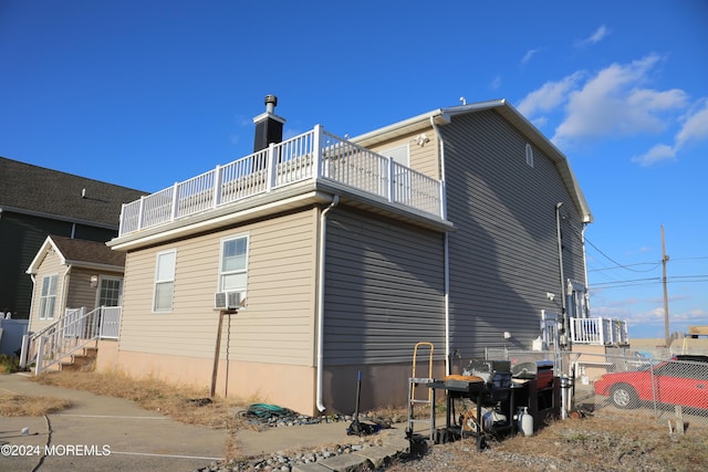 view of side of home with cooling unit and a balcony