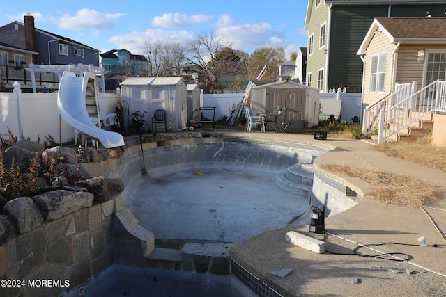 view of swimming pool featuring a storage shed