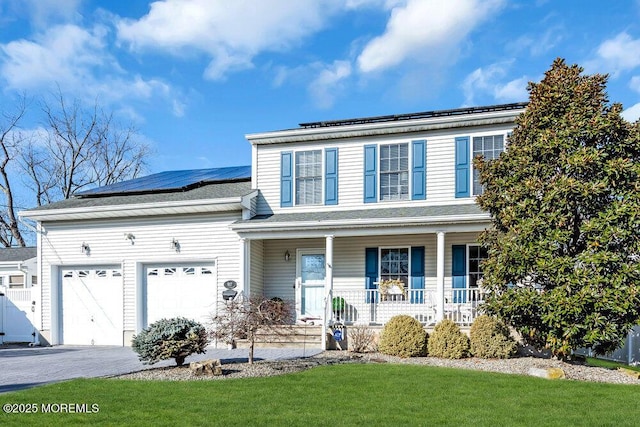 front of property with a garage, a front lawn, solar panels, and covered porch