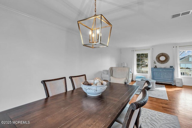 dining space with wood-type flooring and a notable chandelier