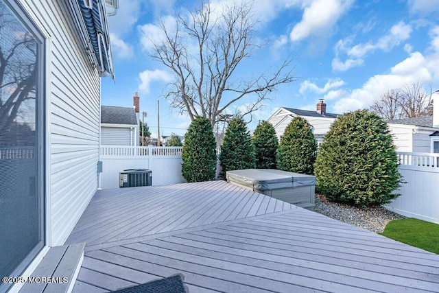 wooden deck featuring cooling unit and a covered hot tub