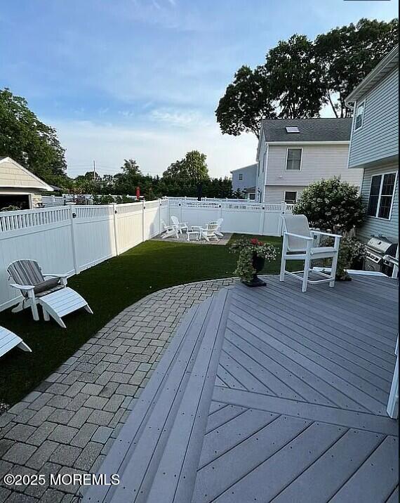 wooden terrace with a yard and an outdoor fire pit