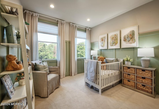 carpeted bedroom featuring a crib