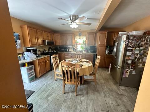 kitchen with ceiling fan, stainless steel appliances, and light hardwood / wood-style floors