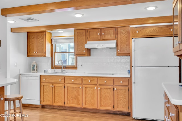 kitchen featuring tasteful backsplash, sink, white appliances, and light wood-type flooring