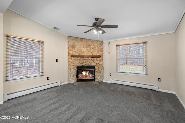 unfurnished living room with a baseboard radiator, a stone fireplace, and a wealth of natural light