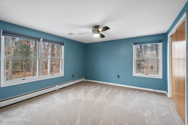 carpeted spare room with ceiling fan and baseboard heating