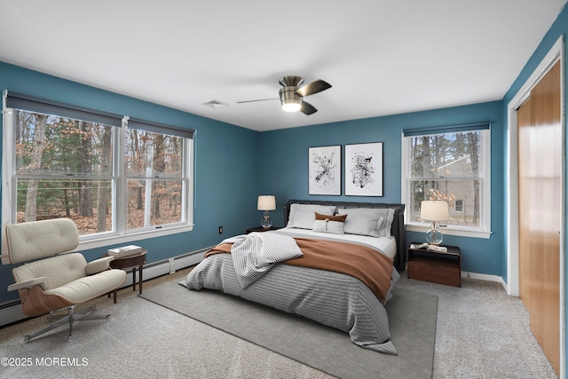 carpeted bedroom with a baseboard radiator and ceiling fan