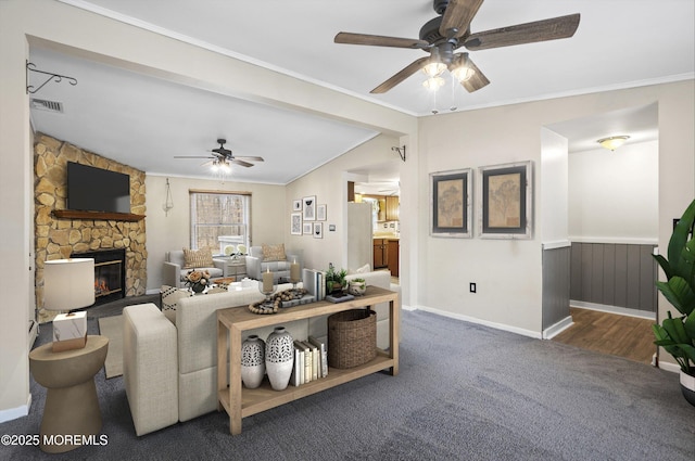 carpeted living room featuring ceiling fan, ornamental molding, a fireplace, and lofted ceiling