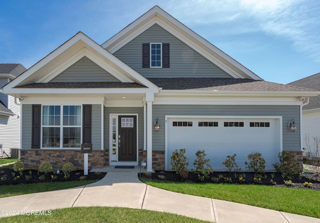 craftsman house with central AC unit and a front yard