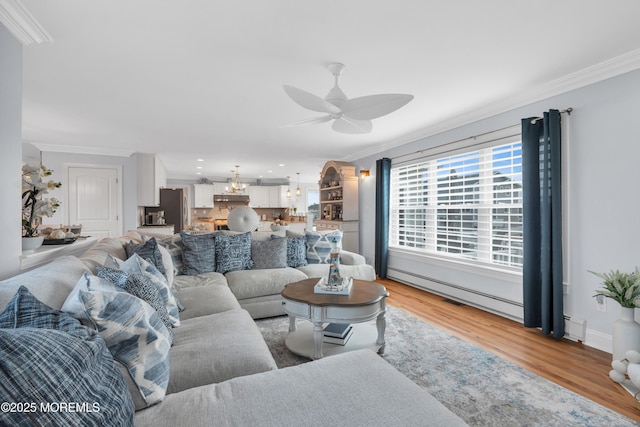 living room with ornamental molding, a baseboard heating unit, ceiling fan, and light hardwood / wood-style floors