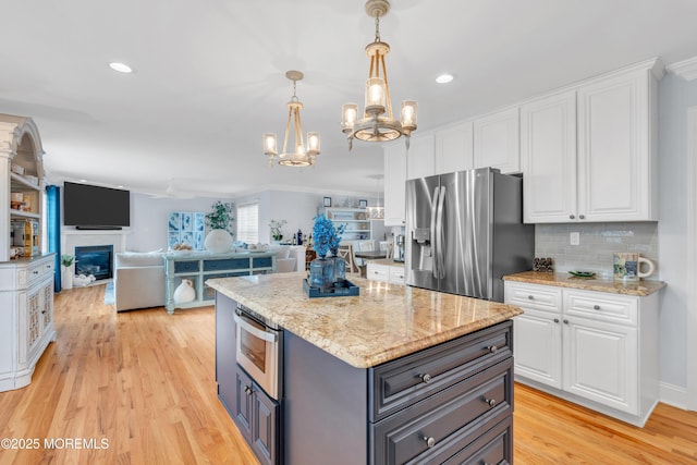 kitchen featuring white cabinetry, decorative light fixtures, and stainless steel fridge with ice dispenser