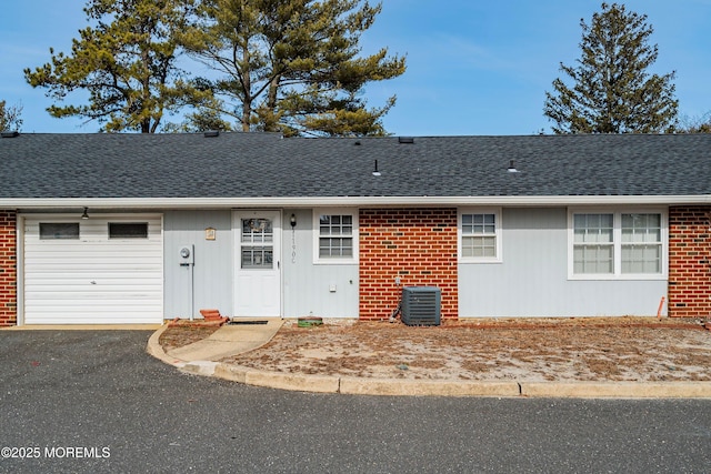 ranch-style home with cooling unit and a garage