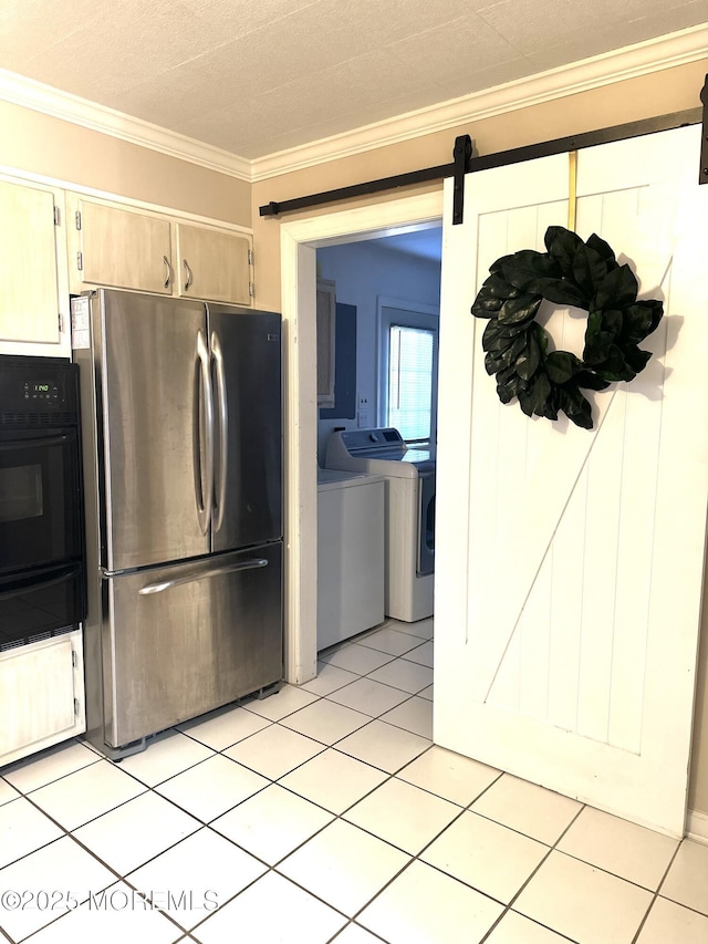 kitchen with light tile patterned flooring, crown molding, separate washer and dryer, stainless steel refrigerator, and a barn door