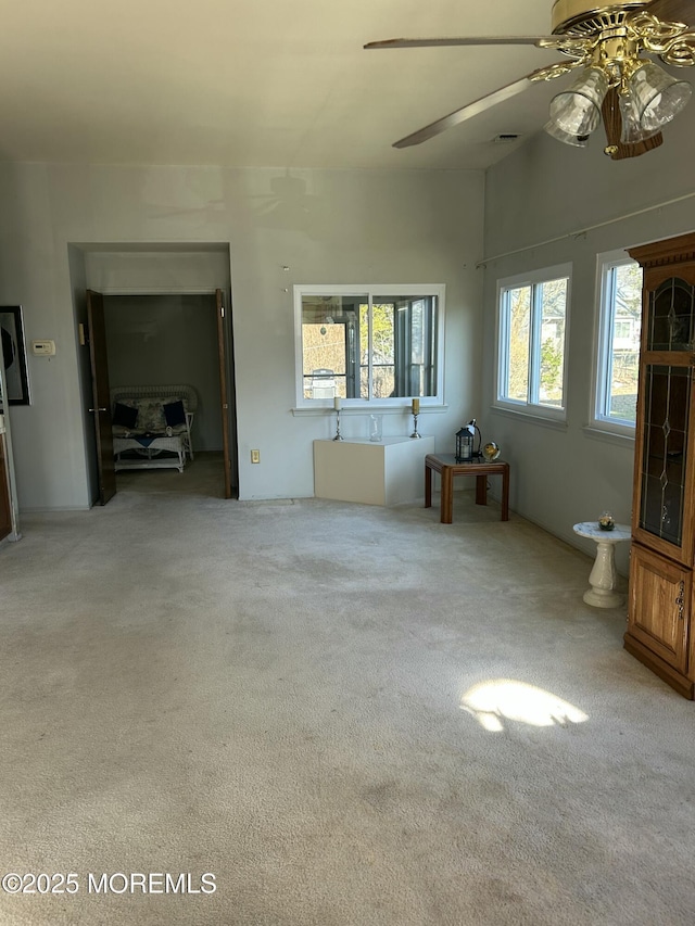 unfurnished living room with carpet flooring and ceiling fan