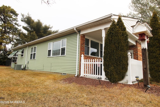 view of side of property with cooling unit and a yard