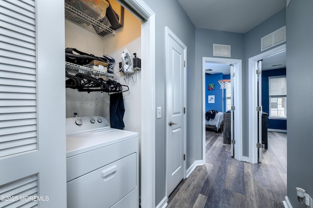 clothes washing area featuring washer / clothes dryer and dark hardwood / wood-style flooring