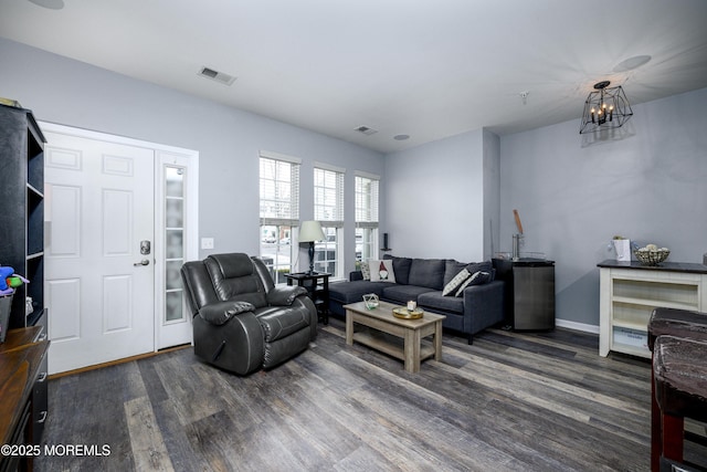 living room with dark hardwood / wood-style floors and a chandelier