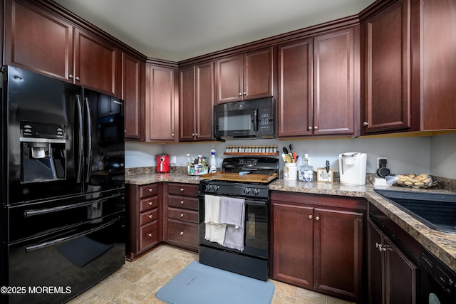 kitchen with light stone counters, sink, and black appliances