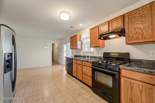 kitchen featuring sink, pendant lighting, dark stone counters, and black appliances