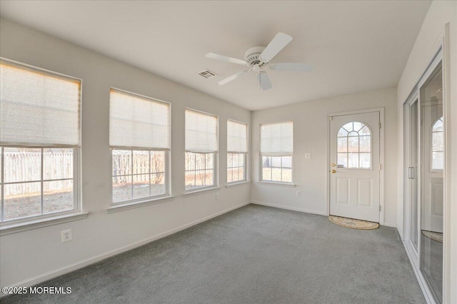 unfurnished sunroom with ceiling fan