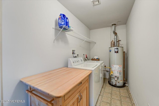 laundry room featuring cabinets, water heater, and washing machine and clothes dryer