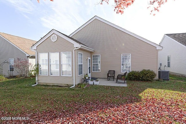 rear view of property featuring central AC unit, a patio, and a lawn