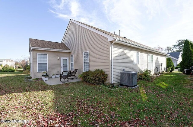 rear view of property with a patio, central AC unit, and a lawn