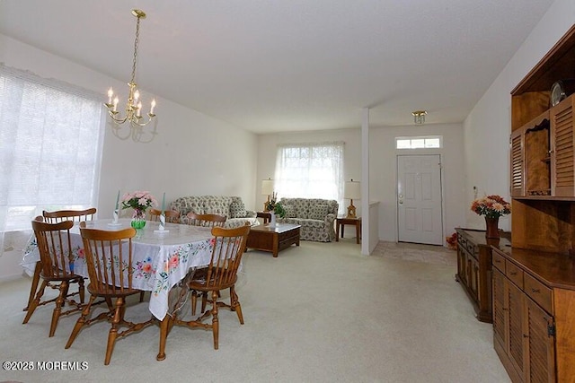 dining room featuring an inviting chandelier and light colored carpet