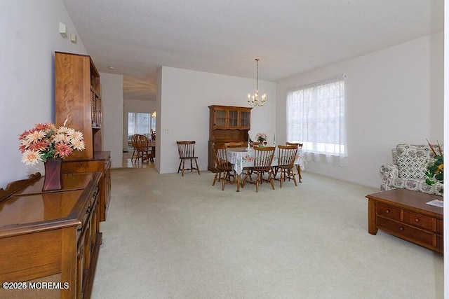 carpeted dining area featuring a chandelier