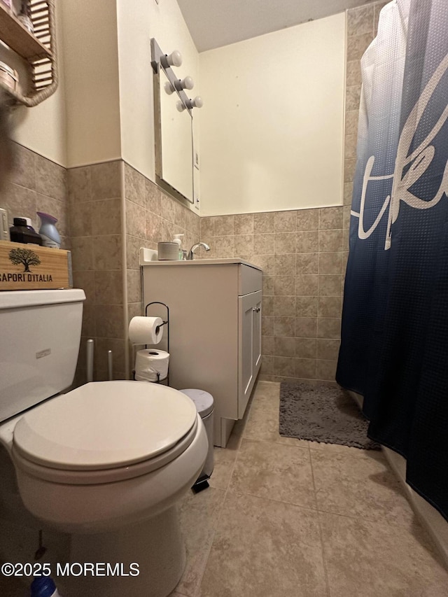 bathroom featuring tile walls, tile patterned floors, and toilet