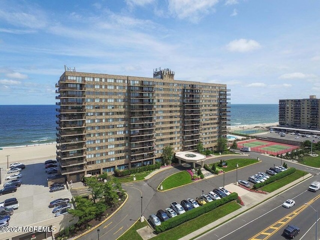 view of property with a water view and a beach view