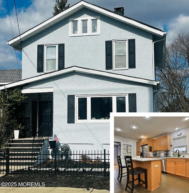 view of front of house featuring stucco siding, a sink, a patio, and exterior bar