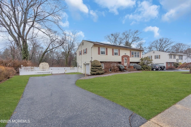 raised ranch with a garage and a front yard