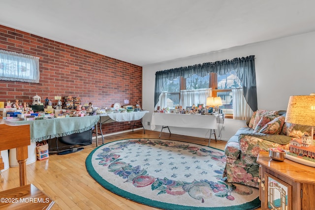 living room featuring hardwood / wood-style flooring and brick wall