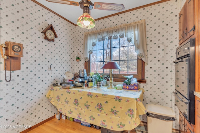 dining space with hardwood / wood-style flooring, ceiling fan, and ornamental molding