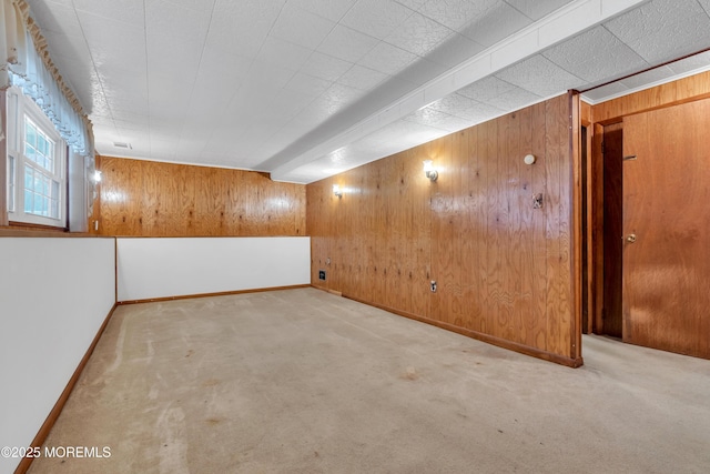 unfurnished room with wooden walls and light carpet