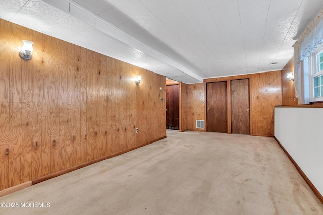 basement with light carpet and wood walls