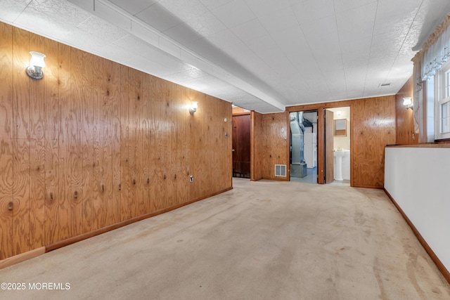 basement with light carpet, wooden walls, and heating unit