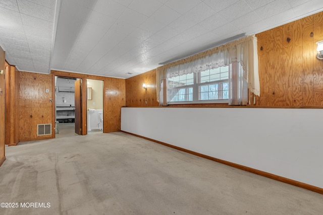 carpeted empty room with wooden walls