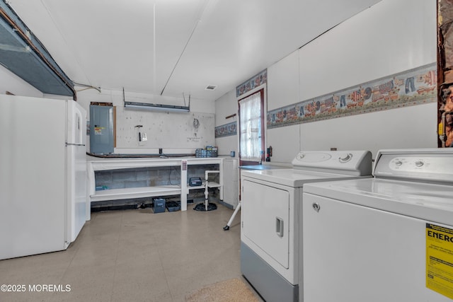 laundry area with electric panel and separate washer and dryer