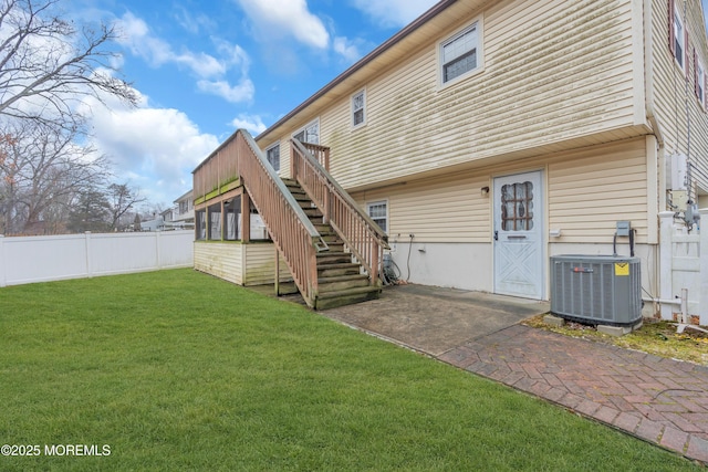 back of house featuring a patio area, central AC unit, and a lawn