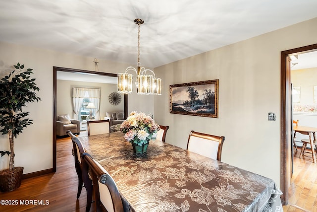 dining area with a chandelier and dark hardwood / wood-style floors