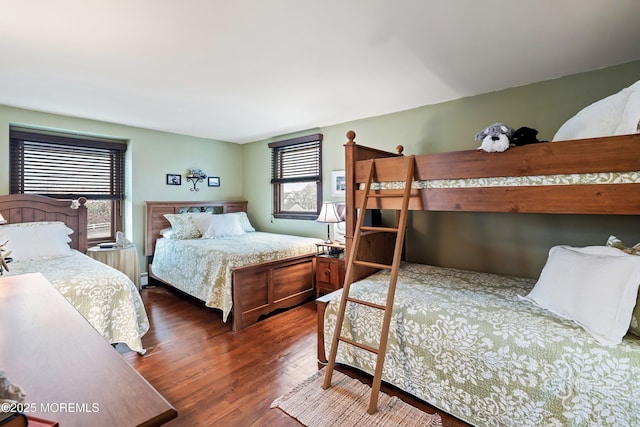 bedroom with baseboard heating and dark hardwood / wood-style floors