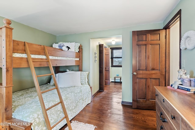 bedroom featuring dark hardwood / wood-style floors and a baseboard heating unit