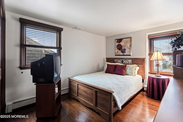 bedroom with a baseboard radiator and wood-type flooring