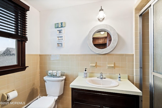 bathroom with tile walls, toilet, vanity, and walk in shower