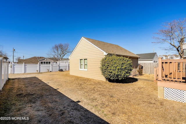 view of side of home with a wooden deck and a lawn