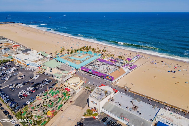 drone / aerial view featuring a water view and a view of the beach