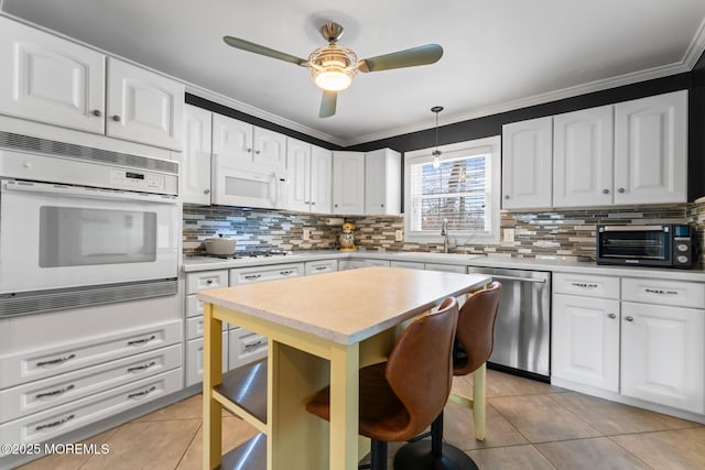 kitchen featuring a breakfast bar, pendant lighting, sink, white cabinets, and stainless steel appliances